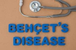 Behçets Disease | Tristate Arthritis & Rheumatology Blue foam letters spell 'BEHCET'S DISEASE' on a corkboard, with a stethoscope resting above the words.